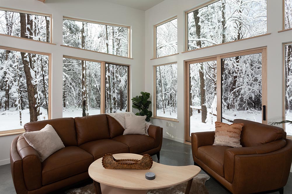 Interior Living space with chairs, couch, and snow outside - the perfect place to come home to after enjoying all of the best things to do in Wausau, WI - and part of our luxury cabin in Wisconsin, one of the best cabin rentals in Wisconsin.