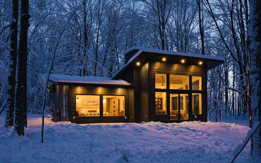 Our gorgeous luxury cabin in WIsconsin lit at night and surrounded by snow - it's by far one of the most unique places to stay in Wisconsin