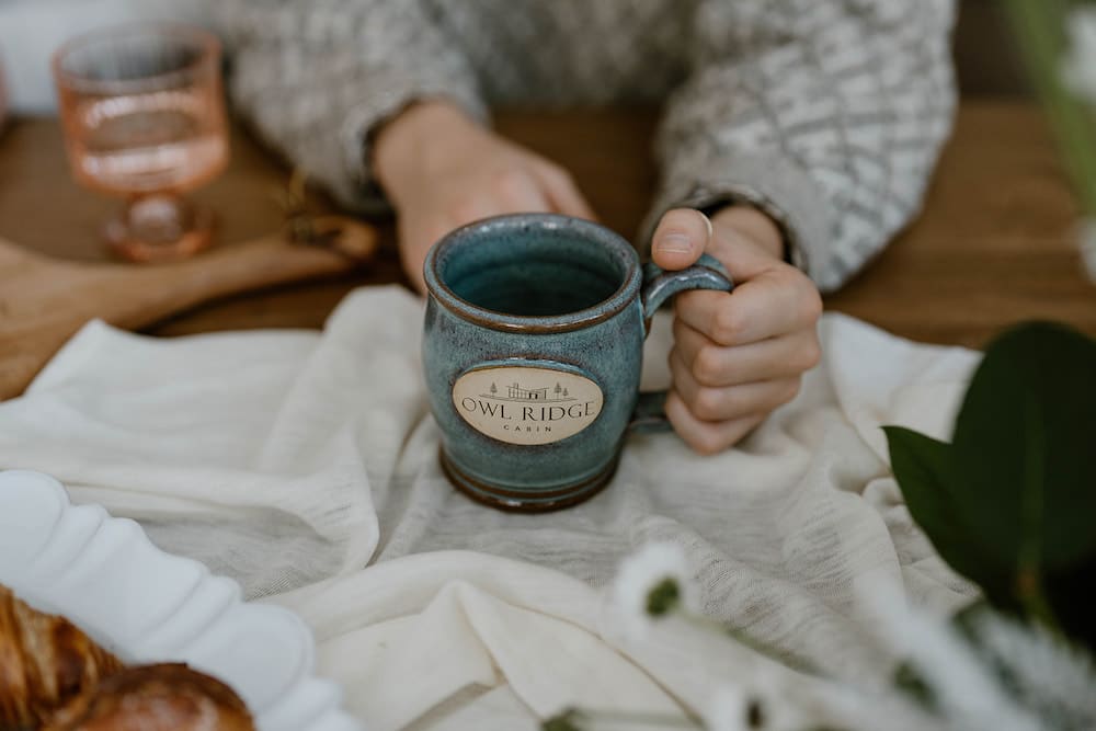 Couple enjoying coffee in the morning with a custom mug at one of the most romantic cabins in Wisconsin